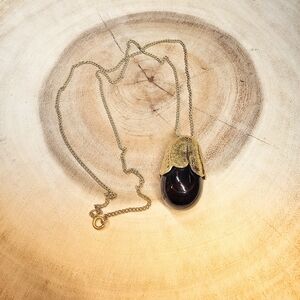 Vintage Avon eggplant perfume bottle necklace.